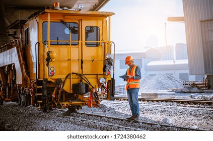 A Engineer Under Inspection Checking Head Train And Railway Switch And Checking Work On Railroad Station .Engineer Wearing Safety Uniform And Safety Helmet In Work.