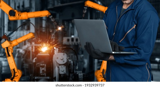 Engineer Use Advanced Robotic Software To Control Industry Robot Arm In Factory . Automation Manufacturing Process Controlled By Specialist Using IOT Software Connected To Internet Network .