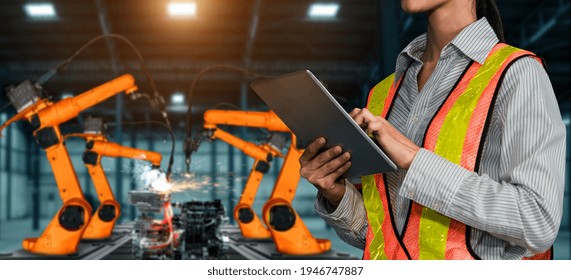 Engineer Use Advanced Robotic Software To Control Industry Robot Arm In Factory . Automation Manufacturing Process Controlled By Specialist Using IOT Software Connected To Internet Network .