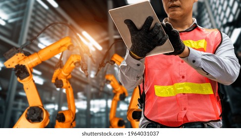 Engineer Use Advanced Robotic Software To Control Industry Robot Arm In Factory . Automation Manufacturing Process Controlled By Specialist Using IOT Software Connected To Internet Network .