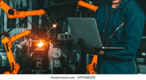 Engineer Use Advanced Robotic Software To Control Industry Robot Arm In Factory . Automation Manufacturing Process Controlled By Specialist Using IOT Software Connected To Internet Network .