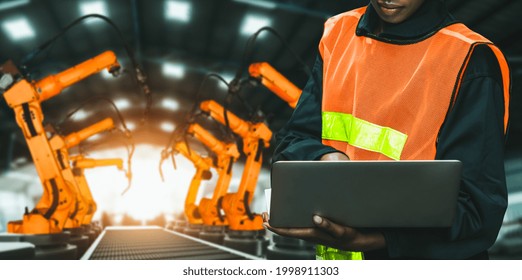 Engineer Use Advanced Robotic Software To Control Industry Robot Arm In Factory . Automation Manufacturing Process Controlled By Specialist Using IOT Software Connected To Internet Network .