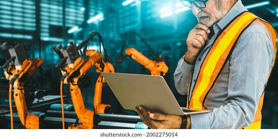 Engineer Use Advanced Robotic Software To Control Industry Robot Arm In Factory . Automation Manufacturing Process Controlled By Specialist Using IOT Software Connected To Internet Network .