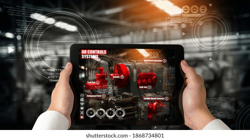 Engineer use augmented reality software in smart factory production line with automated application . Futuristic machinery in working in concept of Industry 4.0 or 4th industrial revolution.