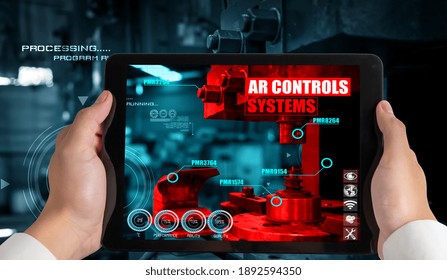 Engineer use augmented reality software in smart factory production line with automated application . Futuristic machinery in working in concept of Industry 4.0 or 4th industrial revolution.
