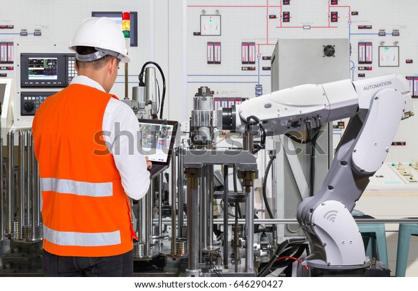 Engineer using laptop computer for maintenance\
automatic robotic hand machine tool in automotive industry,\
Industry 4.0 concept