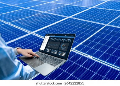 Engineer using laptop to monitor solar energy performance dashboard in solar power plant, renewable energy technology and data analytics for efficient clean energy management system