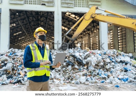An Engineer using a laptop to optimize recycling excavator operations, heavy machinery sorting materials nearby at waste separation plant.