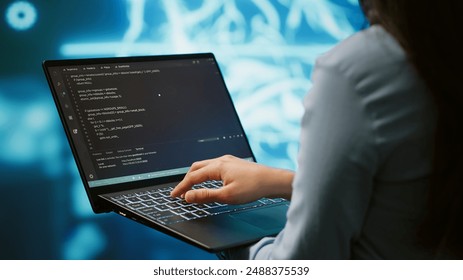 Engineer using notebook to maintenance artificial intelligence neural networks. Close up shot of IT expert using AI system aiding in processing and transmitting information, camera A