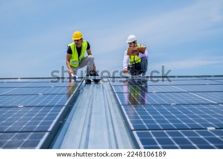 Engineer using pad to running solar system after installation, using solar cell in comercial in industrial level to save the world.
