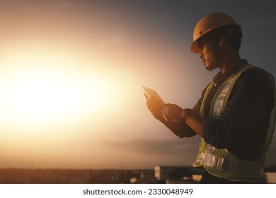 Engineer using tablet to inspect work at job site. concept of technology usage In industrial applications, remote data retrieval, large databases. network link. - Powered by Shutterstock - Get 15% off with code: PIKWIZARD15