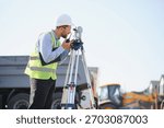Engineer using a total station instrument and radio, working on site infrastructure development. Measuring land for construction