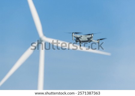 Engineer using UAV Drone technology device to fly survey service maintenance wind turbine power station at wind turbine farm outdoor.