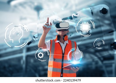 Engineer using virtual reality ui icon display screen using tablet device interacting with machine operating AI robot mechanical hand artificial intelligence technology, working in factory operation.