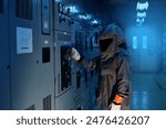 Engineer wear a arc flash protection suit for inspection electrical current and checking status switch gear electrical energy distribution substatio, routine checking, safety suit, low light.