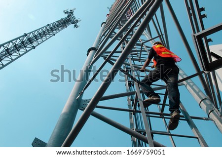 engineer wear safety equipment climb high tower for working telecom maintenance.