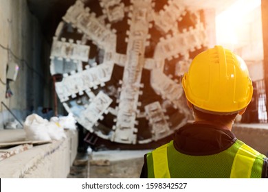 Engineer to wear work clothing,anti-knock helmet safety.Technician control underground tunnel construction at working shaft.Transport pipeline by Tunnel Boring Machine(TBM) method for electric train.