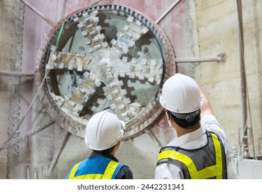 Engineer to wear workwear clothing safety. Technician control underground tunnel construction at working shaft. Transport pipeline by Tunnel Boring Machine(TBM) method for electric train subway. - Powered by Shutterstock