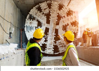 Engineer To Wear Yellow Helmets And Vests Safety.Technician Control Underground Tunnel Construction At Working Shaft.Transport Pipeline By Tunnel Boring Machine(TBM) Method For Electric Train Subway.