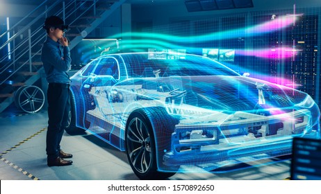 Engineer Wearing Augmented Reality Headset Working On New Electric Car Chassis Platform. 3D Graphics Visualization Virtual Model Of A Vehicle Is Tested In Digital Wind Tunnel.