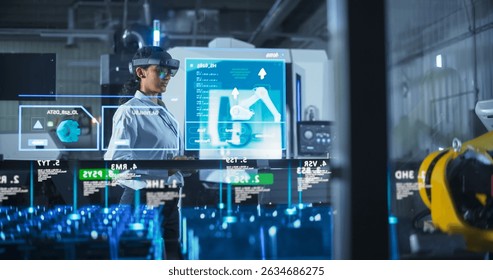 Engineer Wearing Augmented Reality Headset Operates Robotic Arm in a Factory, Interacting With Virtual Controls on a Transparent Holographic Interface. Advanced Machinery and Digital Displays. - Powered by Shutterstock - Get 15% off with code: PIKWIZARD15