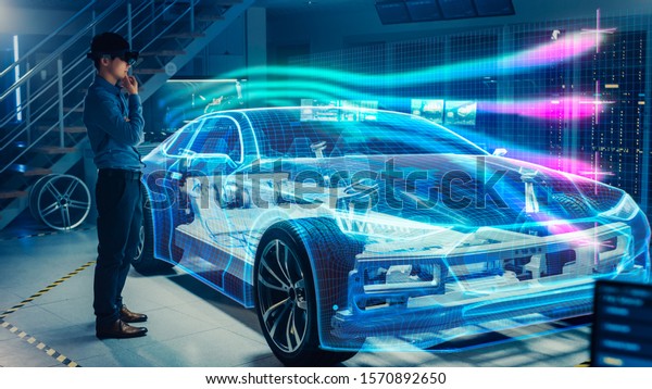 Engineer\
Wearing Augmented Reality Headset Working on New Electric Car\
Chassis Platform. 3D Graphics Visualization Virtual Model of a\
Vehicle is Tested in Digital Wind\
Tunnel.