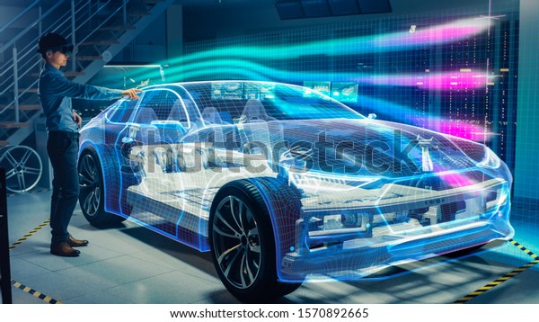 Engineer\
Wearing Augmented Reality Headset Working on New Electric Car\
Chassis Platform. 3D Graphics Visualization Virtual Model of a\
Vehicle is Tested in Digital Wind\
Tunnel.