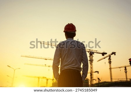 Engineer wearing hard hat looking at construction site with cranes at sunrise, future development, industrial progress, urban growth, ambitious outlook, hope for future