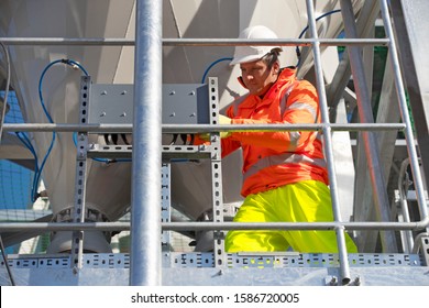 Engineer Wearing Hi Viz Protective Clothing Working On Construction Site Of Cement Processing Plant