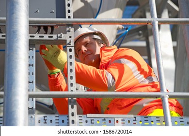 Engineer wearing hi viz protective clothing working on construction site of cement processing plant - Powered by Shutterstock