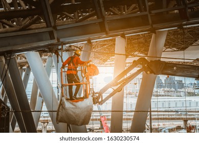 A Engineer wearing safety uniform and safety helmet ,controlling straight Boom Lift to construction roof on sky rail train platform station . - Powered by Shutterstock