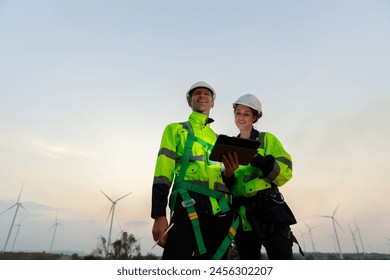 Engineer wearing safety uniform using tablet discussed plan about renewable energy at station energy power wind turbine. technology protect environment reduce global warming problems. - Powered by Shutterstock