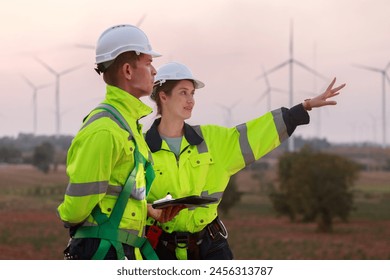 Engineer wearing safety uniform using tablet discussed plan about renewable energy at station energy power wind turbine. technology protect environment reduce global warming problems. - Powered by Shutterstock