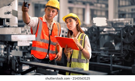 Engineer wearing safety vest controlling machine working talking with assistant engineer worker checking safety first for labour workers. Safety officer check machine in factory. - Shutterstock ID 2143563125