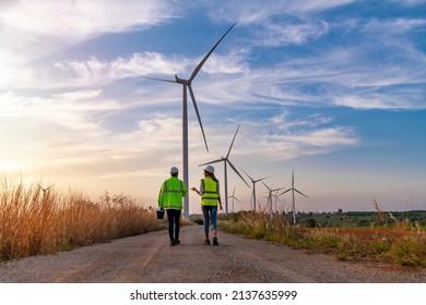 Engineer wearing uniform hold equipment box inspection work in wind turbine farms rotation to generate electricity energy. Green ecological power energy generation wind sustainable energy concept. - Shutterstock ID 2137635999