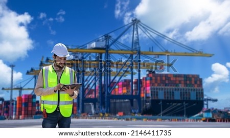 Engineer wearing uniform inspection and see detail on tablet with logistics container dock cargo yard with working crane bridge in shipyard with transport logistic import export background.