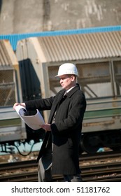 Engineer With White Hard Hat Holding Drawing Near Train