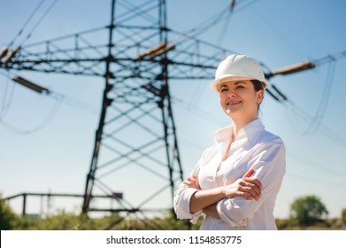 Engineer With White Hard Hat Under The Power Lines. Engineer Work At An Electrical Substation.