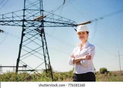 Engineer With White Hard Hat Under The Power Lines. Engineer Work At An Electrical Substation.