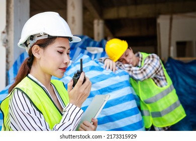 An Engineer Woman Holding A Radio To Report The Work Of A Construction Worker Sleeping On The Job Site. Industrial Concept Of Building Construction Projects. Labor Welfare. Labor Insurance