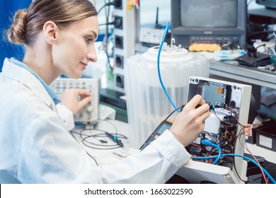 Engineer Woman Measuring Electronic Product On Test Bench In Her Lab For EMC Compliance