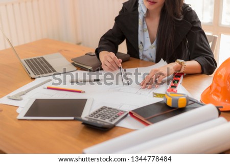 Engineer woman safety helmet on architect ,engineer working table with modern building in office  PaperWorking in coffice concept