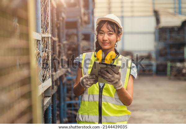 Engineer woman worker, Asian\
working women happy smiling in heavy industry dirty machinery\
factory.