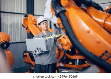 Engineer woman working in advance machine factory. Indian female engineering staff work checking robot arm in assembly plant