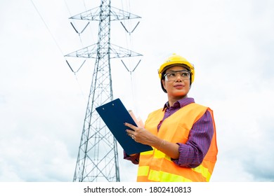 Engineer women using Laptop checking voltage pole Power Transmission. - Powered by Shutterstock