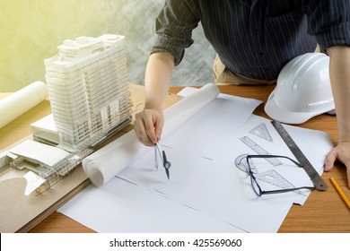 Engineer Work On Table With Architecture Model And White Helmet