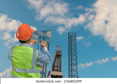 Engineer Work With Tablet For Oil And Gas Industry Drilling Operation On The Platform With Copy Space.