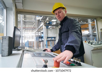 Engineer worker at control room. Portrait of a young technician worker in a factory. The operator monitors the work process from control room