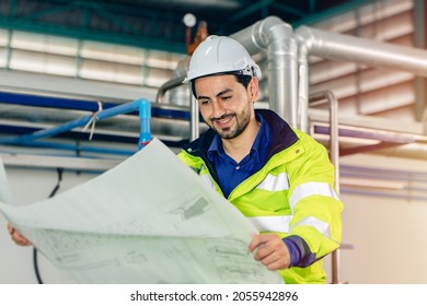 Engineer Worker With Floor Plan Blueprint Paper Of Machine Service Instruction Working In Factory