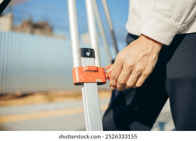 Engineer or worker hand adjusting tripod leg high for optical level - Powered by Shutterstock